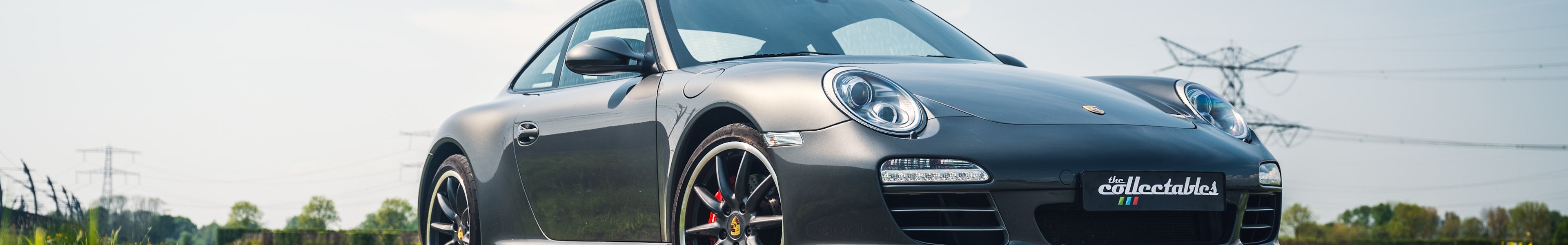 Porsche 997 Carrera 4S Mk II PCG Limited Edition 1 of 5 in grey, front three-quarter view on countryside road under blue sky